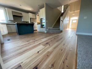 A newly installed carpeted staircase and hardwood flooring in a home by Pg Long Floorcovering LLC in Portland, OR.
