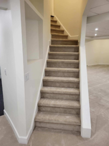 A carpeted staircase in light beige, a completed project by Christie Carpets & Blinds in Rochester, NY