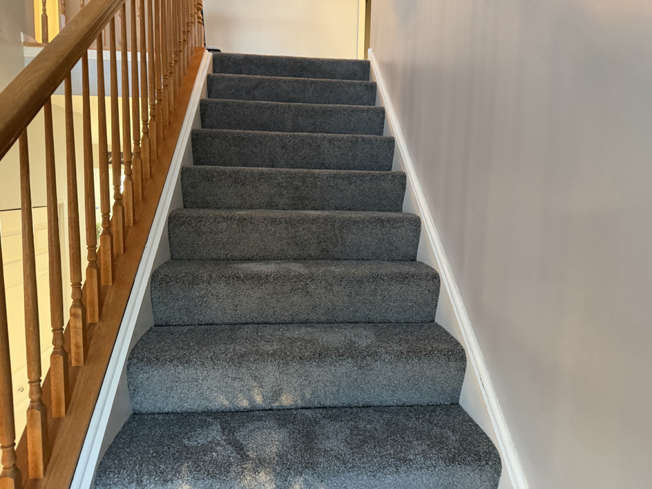 A beautifully carpeted staircase with new grey carpet installed by Carpet Near Me, serving Services Available In.