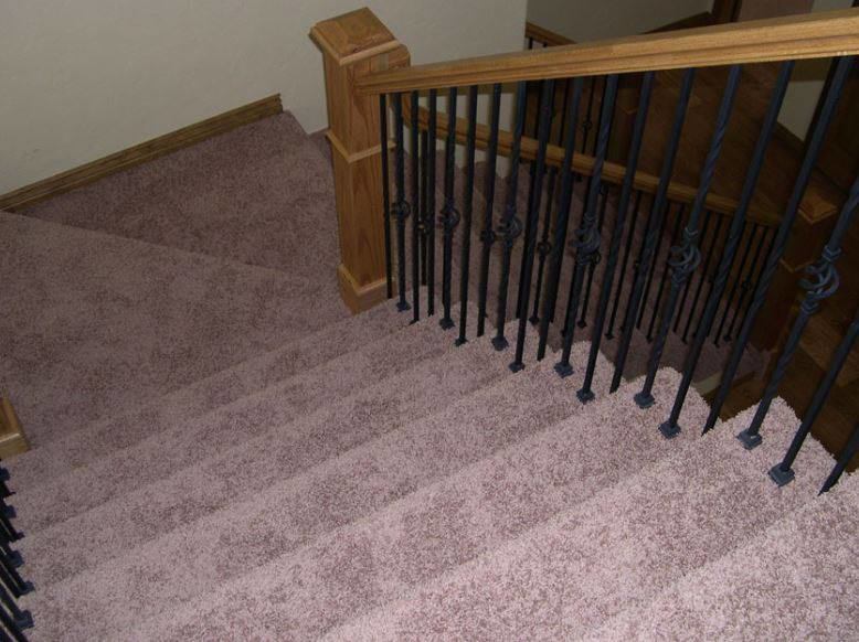 A beautifully carpeted staircase with elegant wooden railings installed by Flooring Cleveland - Ohio City in Cleveland, OH.