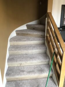A staircase with light-colored carpet treads installed by Grand Rapids Flooring in Grand Rapids, MI.