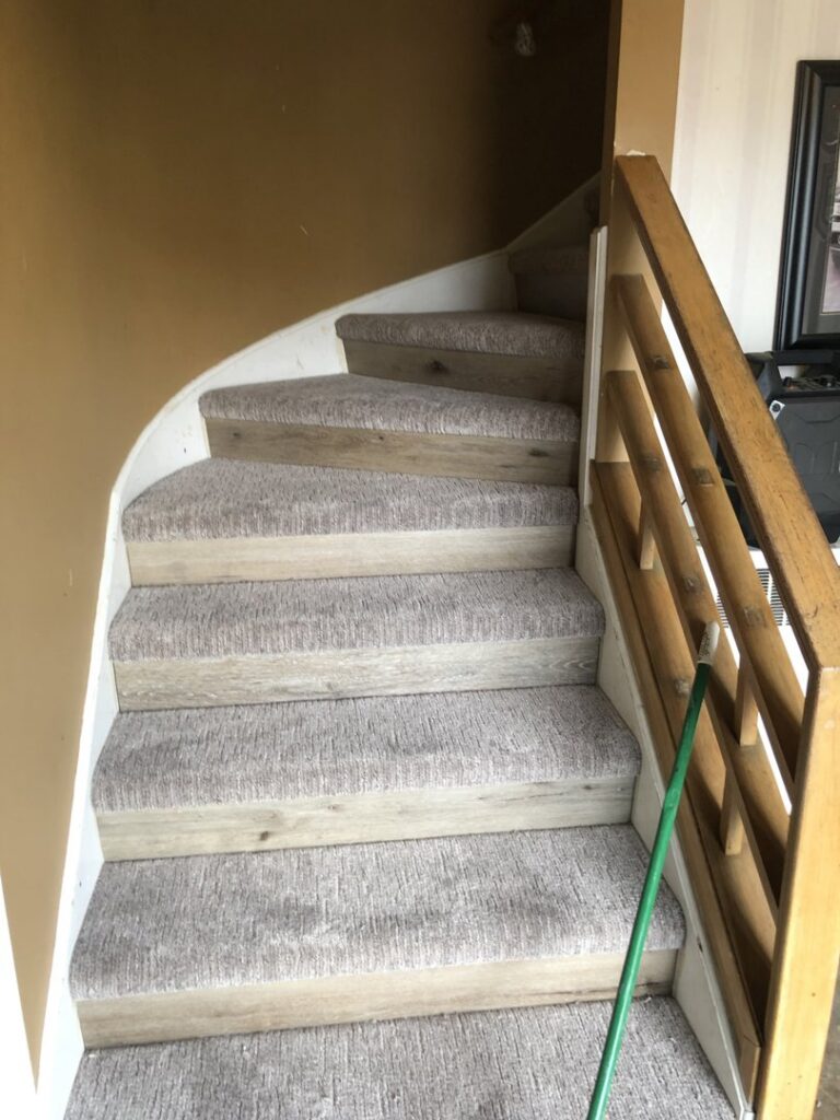A staircase with light-colored carpet treads installed by Grand Rapids Flooring in Grand Rapids, MI.