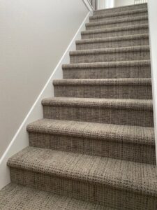A newly carpeted staircase with a textured pattern installed by Independent Flooring in Fort Walton Beach, FL.