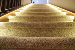 A beautifully carpeted staircase with illuminated steps, installed by Rich's Modern Flooring in Billings, MT.