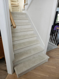 A full flight of newly installed light-colored carpeted stairs by Zubeck Flooring in Blue Springs, MO