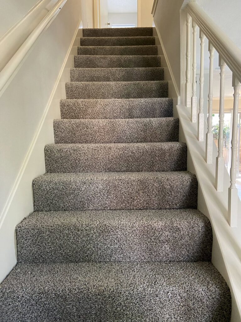 A neatly carpeted staircase in a residential home, installed by Castro's Carpet in Houston, TX.
