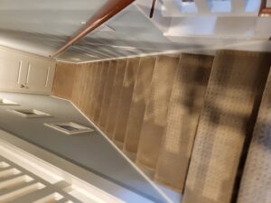 A long, clean carpeted staircase viewed from the top, showcasing carpet installation by Greenco2 in Grand Rapids, MI.