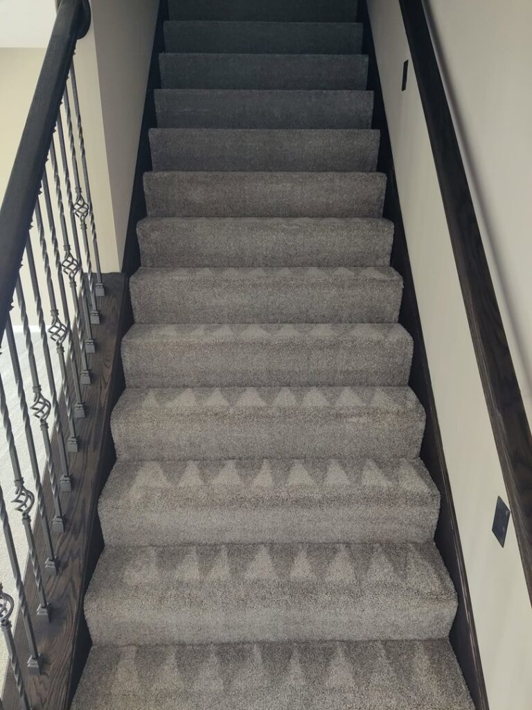Freshly cleaned carpeted stairs with visible vacuum lines by 765 Custom Cleaners in Lafayette, IN.