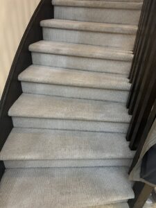 Light gray carpeted stairs with visible cleaning marks, serviced by PROlific Cleaning Services LLC in Indianapolis, IN.
