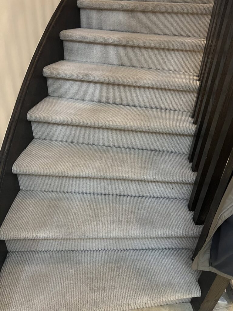 Light gray carpeted stairs with visible cleaning marks, serviced by PROlific Cleaning Services LLC in Indianapolis, IN.