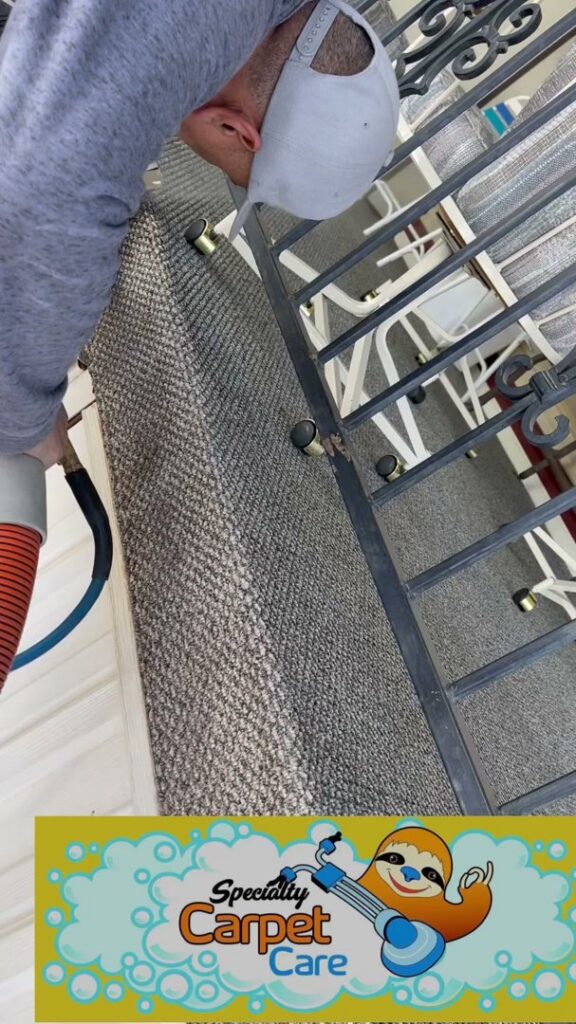 A professional cleaning carpeted stairs with a specialized tool by Specialty Carpet Care in Surprise, AZ