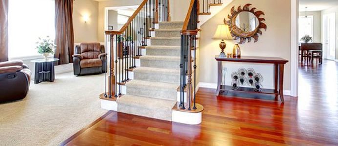 Beautiful carpeted stairs and a cozy living room with new hardwood flooring in the foyer by Footprints Floors in Chicago, IL.