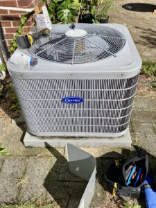 A Carrier AC condenser unit undergoing service or repair by Infinite Heating & Air in Newnan, GA.
