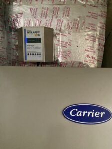 A Carrier indoor air handler with a Solaris Whole House Air Purifier installed by T&D Air Conditioning in Fort Lauderdale, FL.