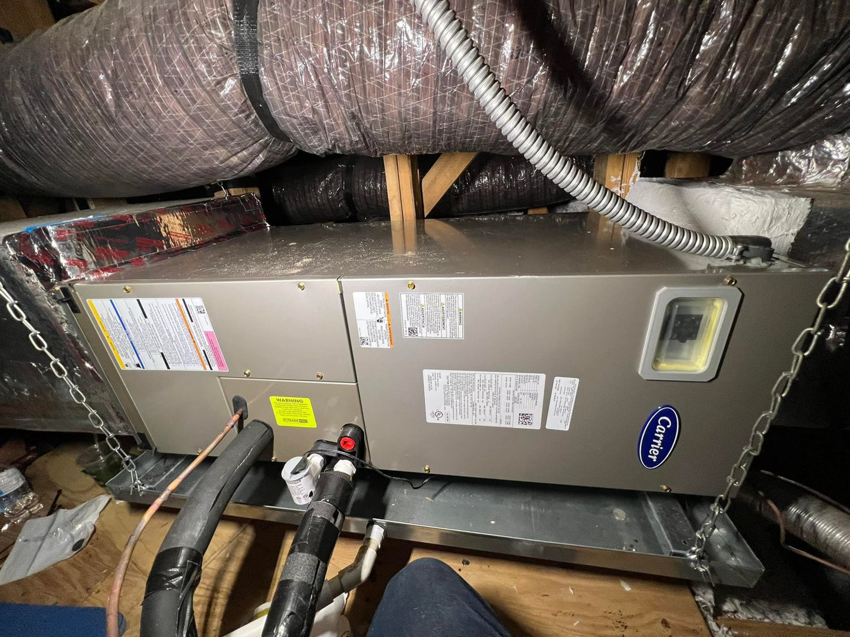 A Carrier air handler unit installed in an attic with ductwork by AC All Stars AC contractor in Fort Lauderdale, FL.