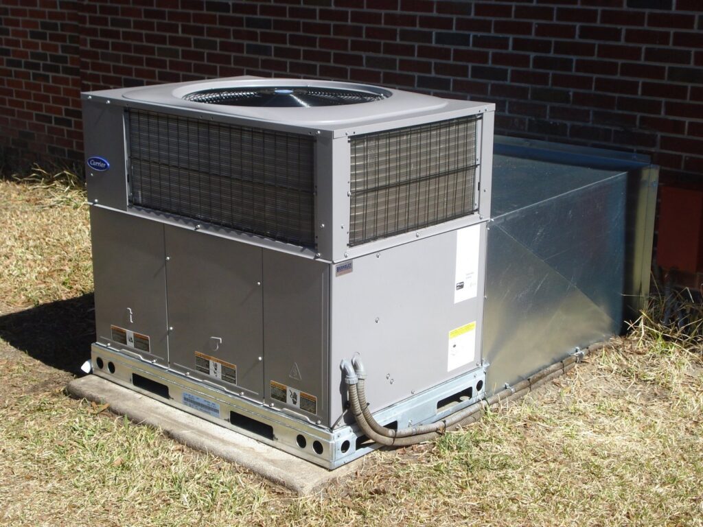 A large Carrier commercial HVAC unit installed outside a brick building by Berkeley Heating and Air Conditioning in Hanahan, SC