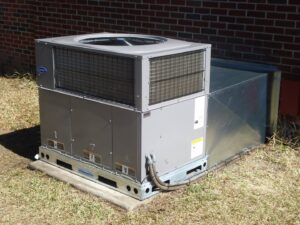 A large Carrier commercial HVAC unit installed outside a brick building by Berkeley Heating and Air Conditioning in Hanahan, SC
