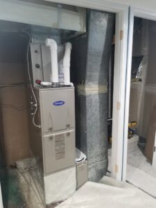A Carrier furnace and air handler unit with ductwork installed in a utility space by Jv Services inc. in Pinellas Park, FL.
