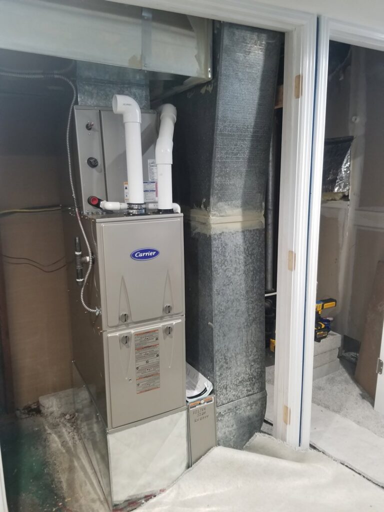A Carrier furnace and air handler unit with ductwork installed in a utility space by Jv Services inc. in Pinellas Park, FL.