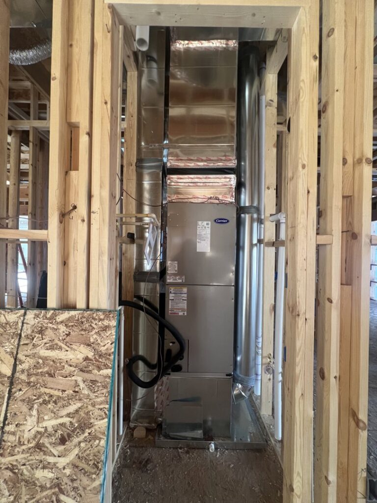 A Carrier furnace and air handler unit installed within the framing of a new construction home by Vanessa Service HVAC in Falls Church, VA.