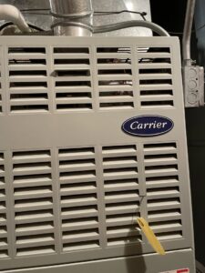 A Carrier brand furnace or air handler unit, indicating HVAC equipment installation or service by Your HVAC Guy in Aurora, IL.