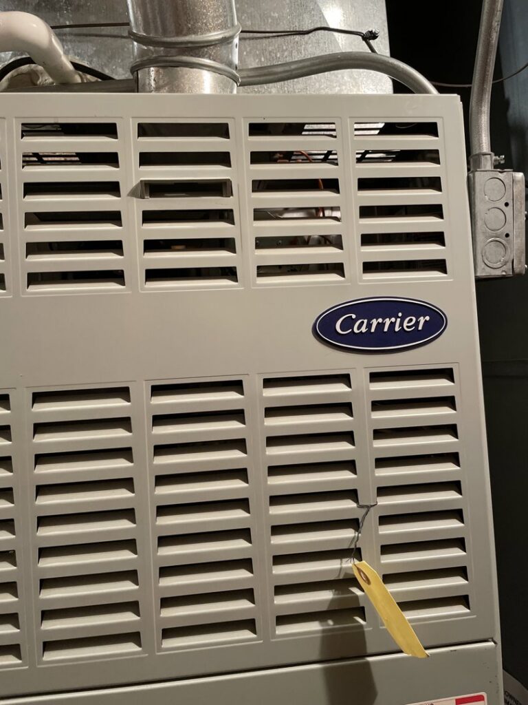 A Carrier brand furnace or air handler unit, indicating HVAC equipment installation or service by Your HVAC Guy in Aurora, IL.