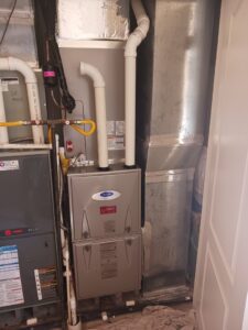 A Carrier furnace and associated ductwork installed in a utility area by MMI Climate Solutions in Lexington, KY.