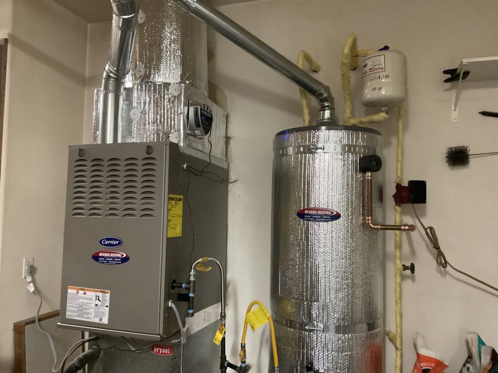 An indoor Carrier furnace and water heater installation with ductwork by Nevada Heating Reno in Sparks, NV.