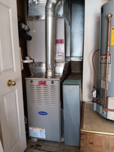 A newly installed Carrier furnace and ductwork in a utility closet by MMI Climate Solutions in Lexington, KY.