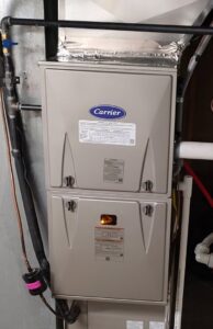 A Carrier furnace unit with a visible flame, indicating operation or testing by Wyles Heating & Air Conditioning Inc. in North Canton, OH.