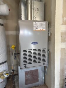A Carrier furnace and water heater with ductwork installed in a utility space by Nevada Heating Reno in Sparks, NV.