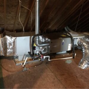 A Carrier HVAC air handler unit with ductwork installed in an attic by Systematic Heating & Air in Winston-Salem, NC.
