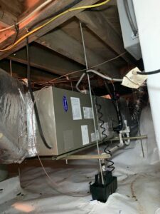 A Carrier HVAC air handler unit with ductwork installed in a crawl space by Systematic Heating & Air in Winston-Salem, NC.