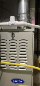 A Carrier brand HVAC furnace with ductwork and a safety switch, installed by Hawthorne Heat & Air in Pollock, LA.