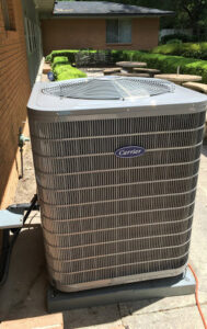A newly installed Carrier HVAC outdoor unit next to a residential building by Air Control Heating and Cooling in Tallahassee, FL.