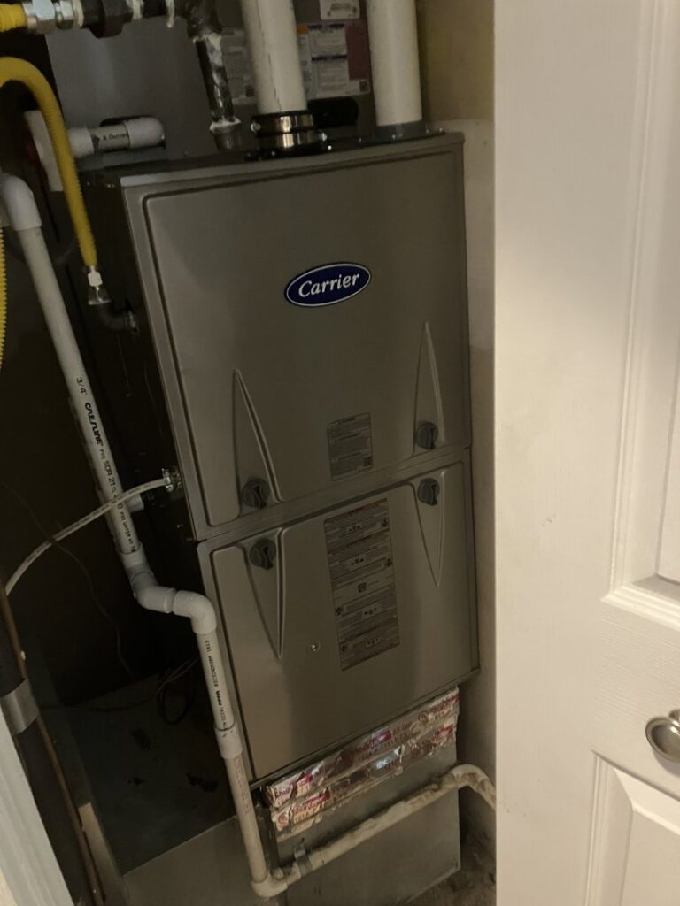An indoor Carrier furnace and air handler unit installed in a utility closet by JDL HVAC Services, LLC in Laurel, MD.