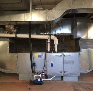 A Carrier indoor HVAC furnace and air handler unit with ductwork installed by Systematic Heating & Air in Winston-Salem, NC.