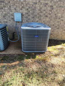 An outdoor Carrier air conditioning condenser unit installed next to a brick home by Smith Heat an Air, LLC in Southaven, MS.