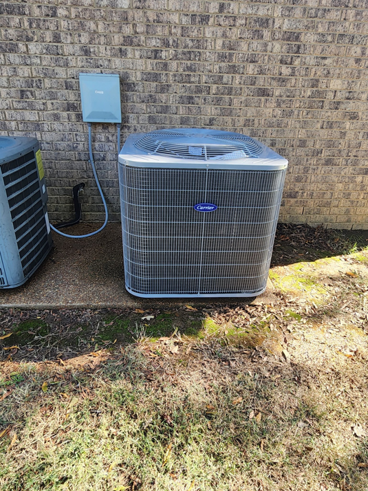 An outdoor Carrier air conditioning condenser unit installed next to a brick home by Smith Heat an Air, LLC in Southaven, MS.