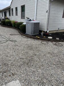 A Carrier outdoor AC unit installed by BC Express Inc Heating & Air Conditioning next to a home in Toms River, NJ.