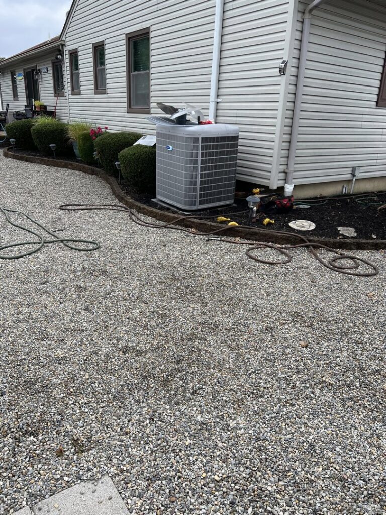 A Carrier outdoor AC unit installed by BC Express Inc Heating & Air Conditioning next to a home in Toms River, NJ.