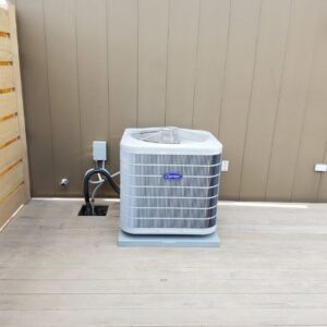 A Carrier outdoor air conditioning unit installed on a deck by Cosmic HVAC in Chicago, IL.