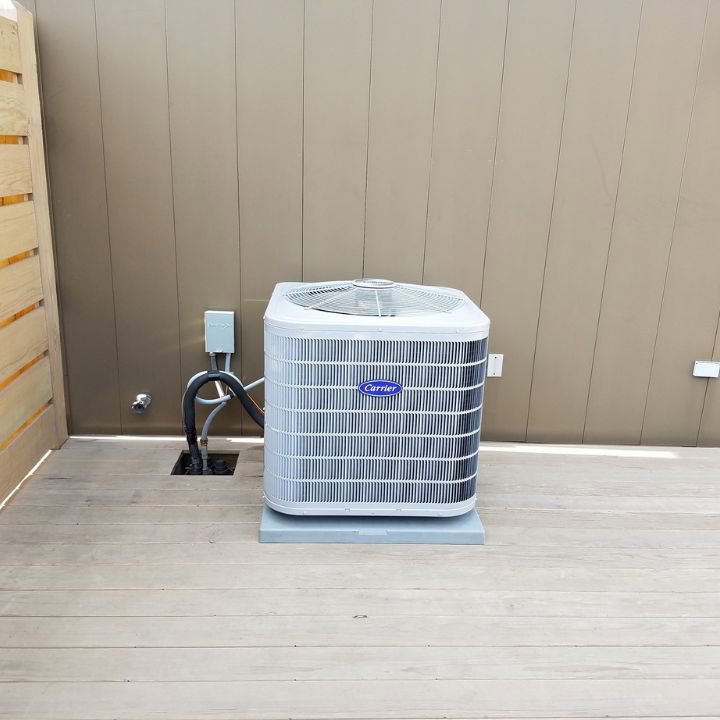 A Carrier outdoor air conditioning unit installed on a deck by Cosmic HVAC in Chicago, IL.