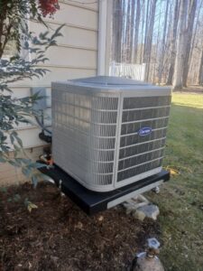 An outdoor Carrier AC unit installed next to a residential building by JDL HVAC Services, LLC in Laurel, MD.