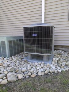 A Carrier outdoor air conditioning unit installed next to a residential building, a service by McTeer's Heating & Cooling in Salisbury, MD.