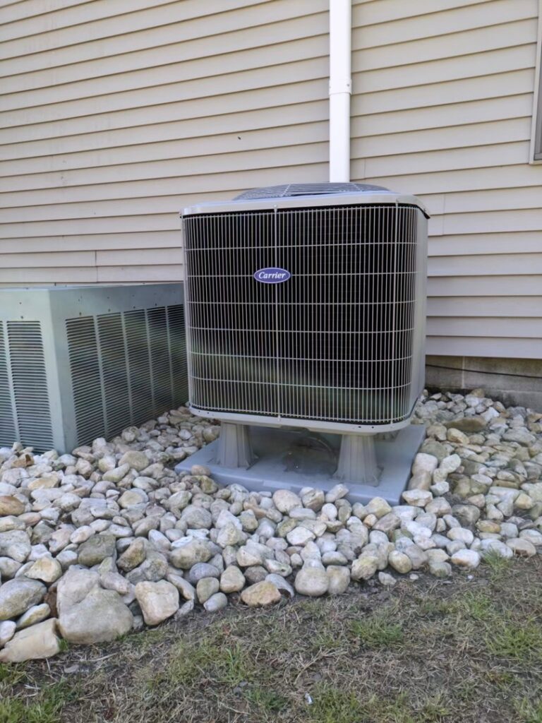 A Carrier outdoor air conditioning unit installed next to a residential building, a service by McTeer's Heating & Cooling in Salisbury, MD.