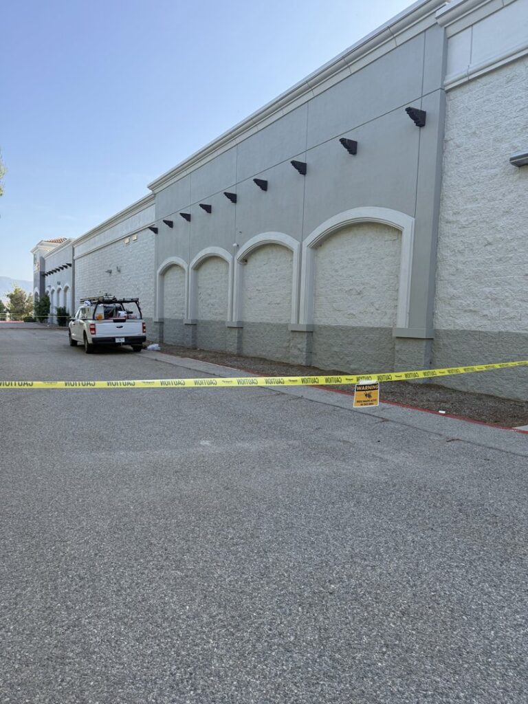 Caution tape and a warning sign around a commercial building during a pest control job by BeeCal Pest Management in Los Angeles, CA