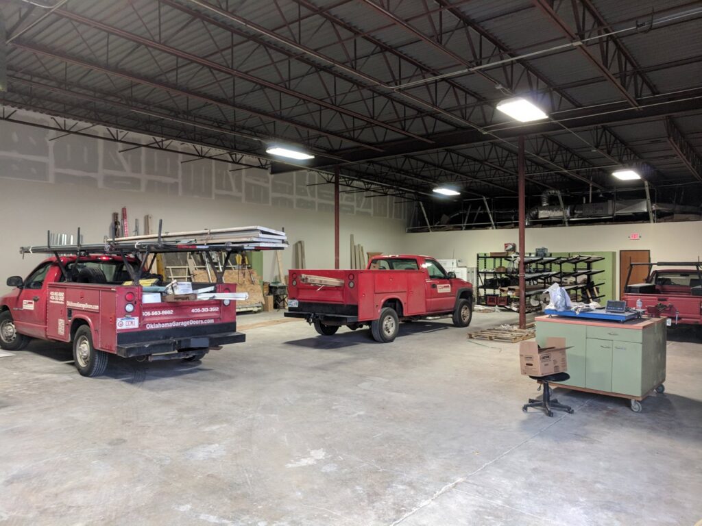 Interior view of the CCM Overhead Doors warehouse with service trucks ready for garage door contractor jobs in Oklahoma City, OK.