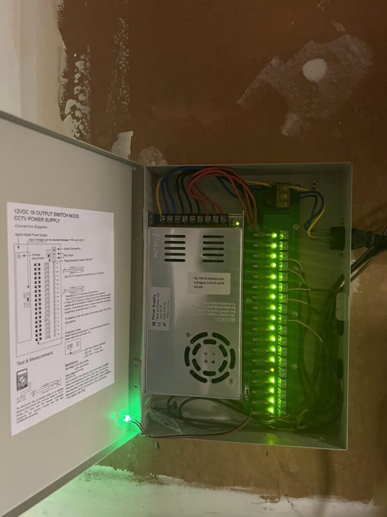 CCTV power supply with multiple wired connections and green indicator lights installed by Andrew's Electric in Kent, WA