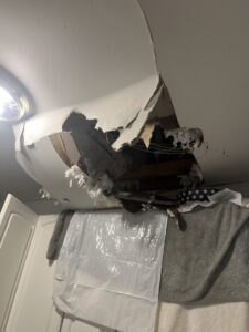 Ceiling damage with exposed insulation, likely from a water leak, requiring repair by Komfort Air Service Experts in Charlotte, NC.